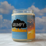 Candle jar labeled 'Grumpy Sunshine' with a cloud design against a blue sky background.