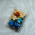 Star-shaped wax melts in a clear plastic packaging on a marble surface